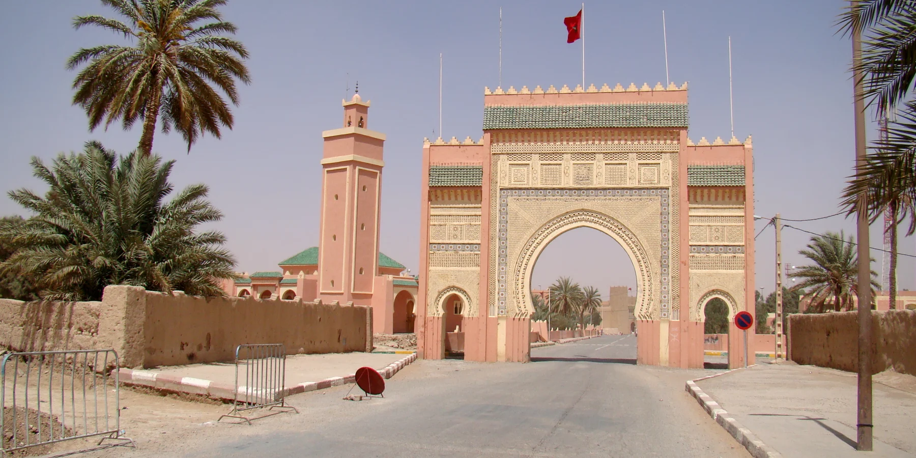 A decorated entrance gate and palms in Rissani