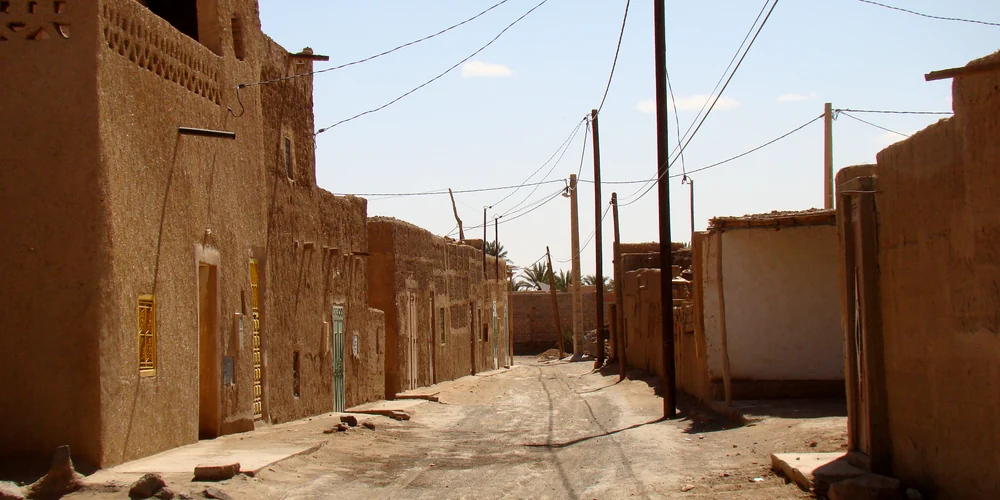 Earthen buildings and a narrow street in Merzouga’s older town