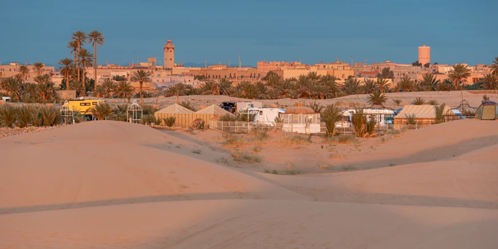 Buildings and palms in a view towards Hassilabied beside the dunes